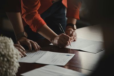 Two people reviewing and signing documents at a table
