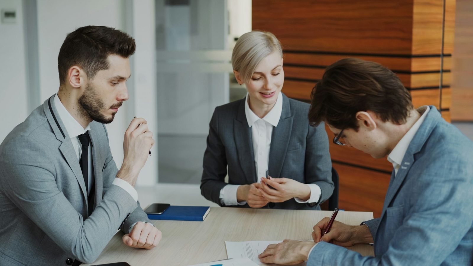 Business partners reviewing and signing an agreement at a table